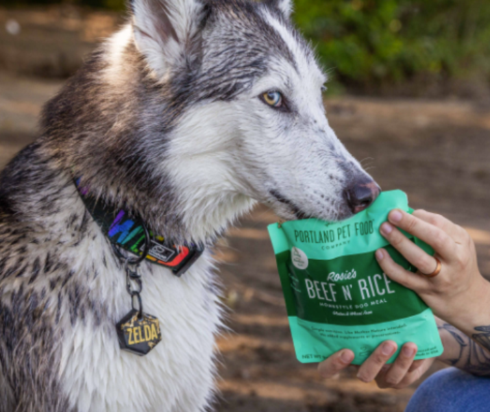 A dog enjoying Portland Pet Food Company's limited ingredient dog food toppers.